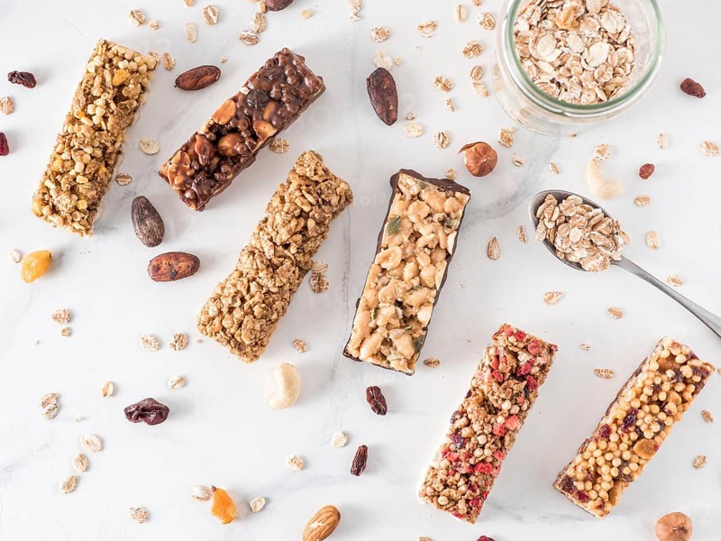 Granola bar with copy space. Set of different granola bars on white marble table. Shallow DOF. Top view or flat lay
