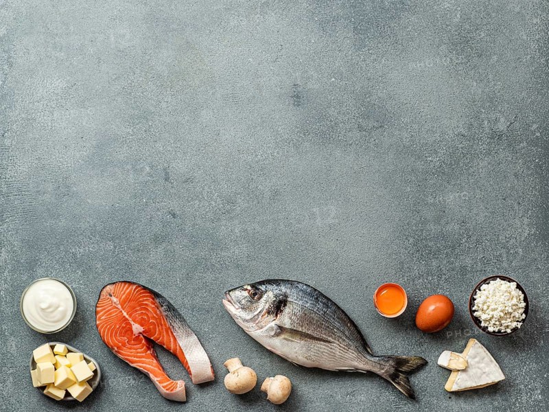 Vaitamin D sources concept with copy space for text. Fish, salmon, dairy products, eggs, mushrooms on gray stone background. Top view or flat lay. Copy space top
