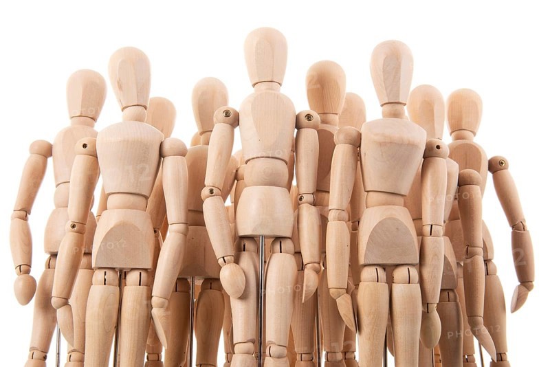 Many wooden mannequins isolated over white