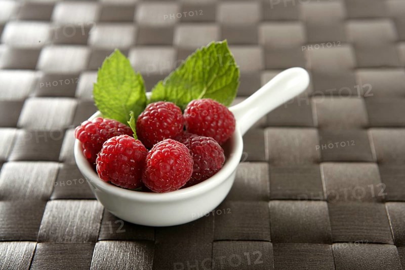 Raspberries with basil leaves, fresh natural dessert