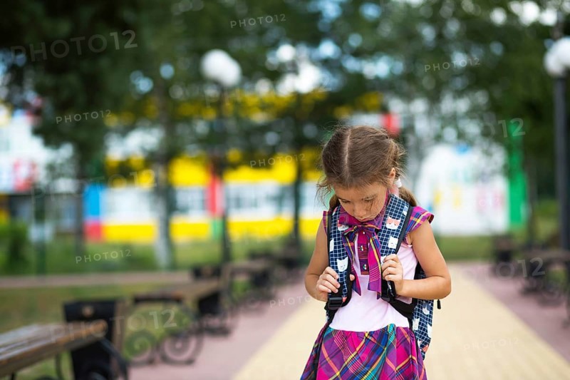 Sad, upset girl near the school with a backpack. Fatigue from classes, resentment, lessons not learned, a bad mark. Back to school. Copy space