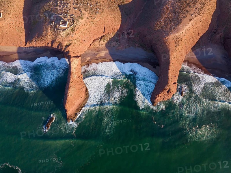 Aerial top view on Legzira beach with arched rocks on the Atlantic coast at sunset in Morocco