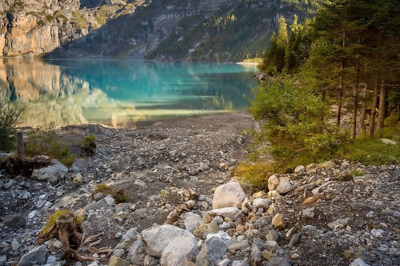 Oeschinensee lake in Switzerland in autumn, landscape photography, crystalic blue water, trees