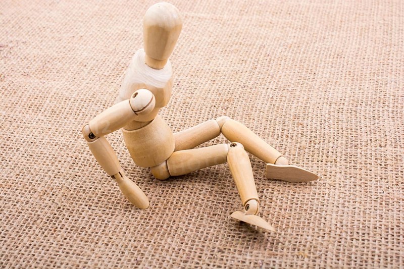 Wooden dolls of a man posing on canvas