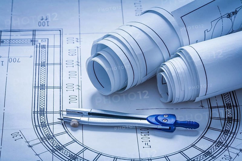 Rolled up construction sketches and drawing compass building concept