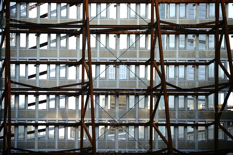 A heavy iron construction supports a single wall of a demolished tower block