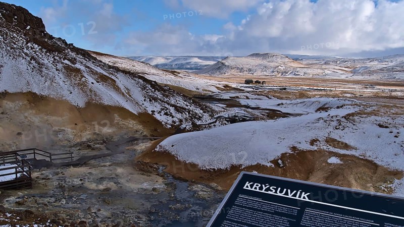 Seltún, Krýsuvík, Iceland, 03-23-2021: View over geothermal area Seltún, part of volcanic system Krýsuvík, with steaming hot springs, fumaroles and information board on cloudy winter day
