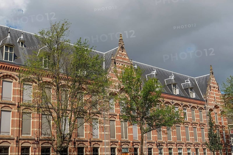 Historic buildings with gables and trees, cloudy sky, Amsterdam, Netherlands