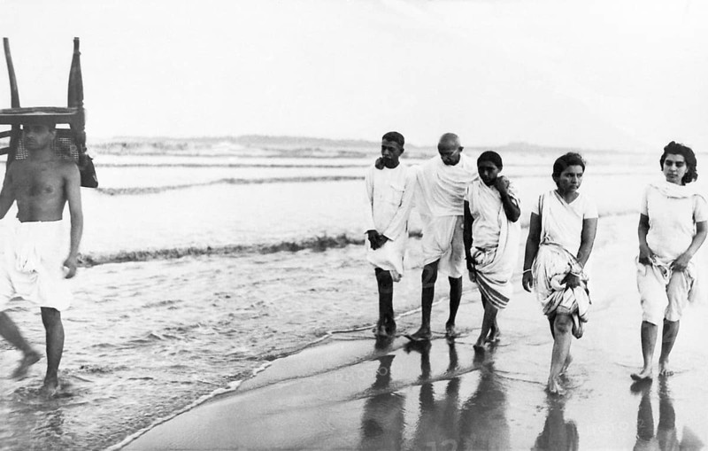 Mahatma Gandhi and others walking Juhu Beach, Mumbai, May 1944, Kanu Gandhi, carrying a chair on his head, Sushila Nayar, India NO MR