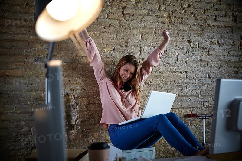 Excited happy young woman at office open arms with laptop