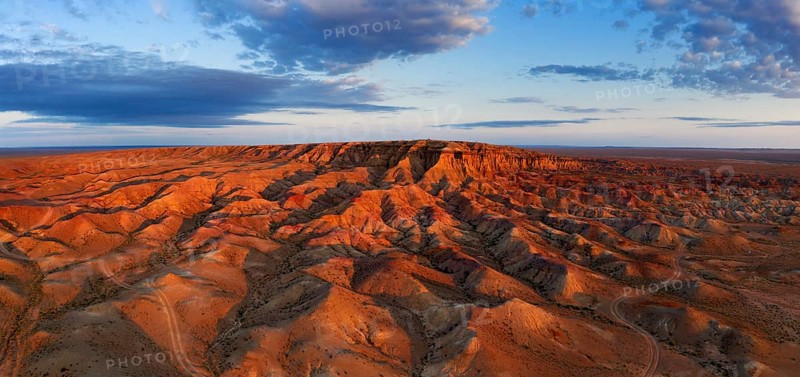 Aerial panorama of textural colorful striped canyons Tsagaan suvarga, White stupa at sunrise. Ulziit soum, Dundgovi province, Mongolia