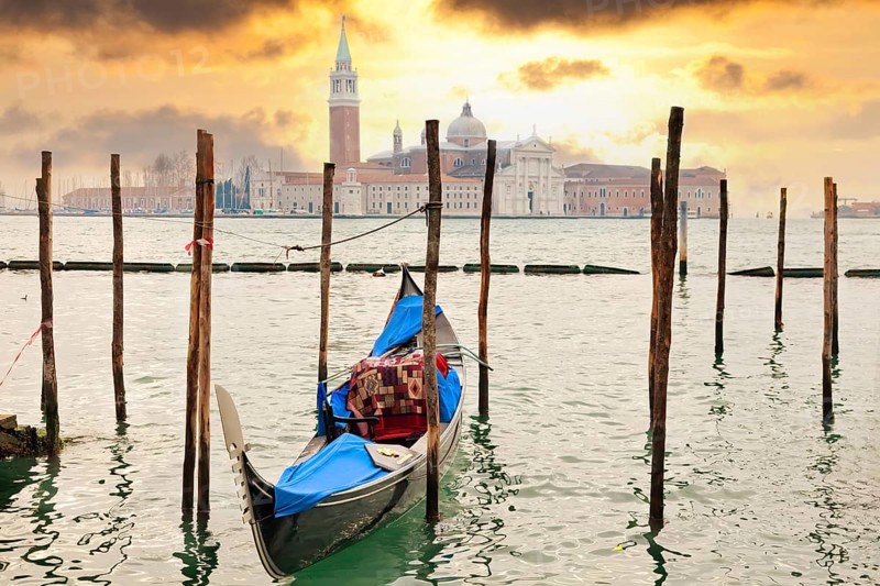 Gondola at sunset pier near San Marco square in Venice, Italy