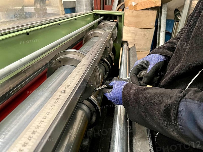 Technician worker placing the blades of a machine to cut steel coils. Industrial environment and business concept