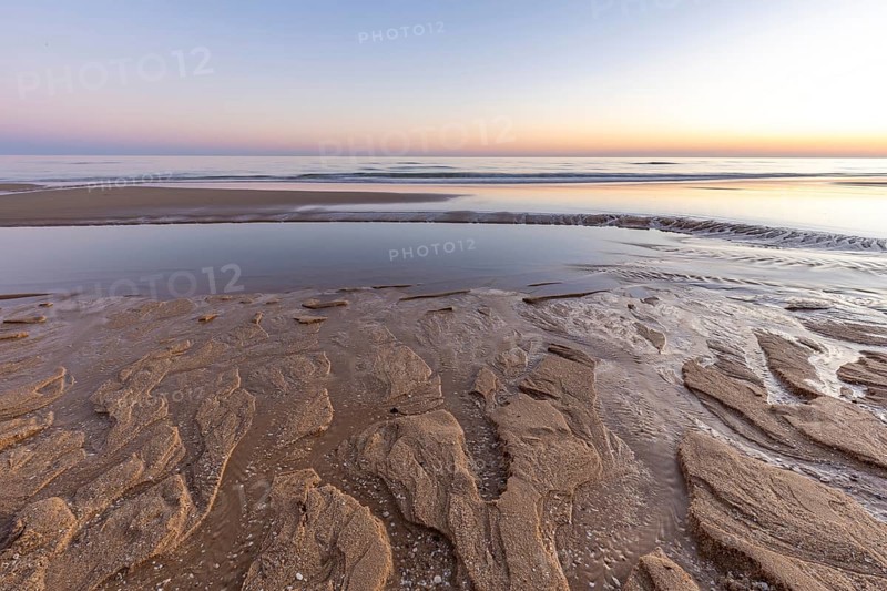 What a sandy beach on the Atlantic. Landscape shot at sunset on a coast with sandstone cliffs. Low tide on the yellow beach of Praia da Falésia near Albufeira, Algarve, Portugal