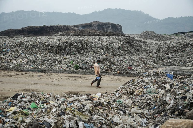 A person walking between garbage heap at a garbage dumpsite in the eve of World Environment Day, in Guwahati, Assam, India on 04 June 2022. World Environment Day is the biggest international day for the environment. Led by the United Nations Environment Programme (UNEP) on June 05 every year