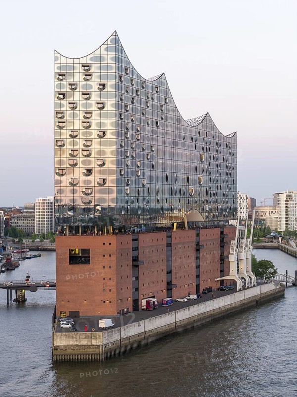 The Elbphilharmonie concert hall in Hamburg is reflected in the glass design above the historic Kaispeicher warehouse, Hamburg, Germany