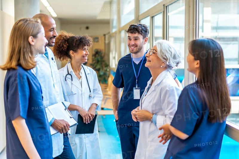 Doctors and nurses sharing a friendly moment, talking and smiling together in a hospital corridor