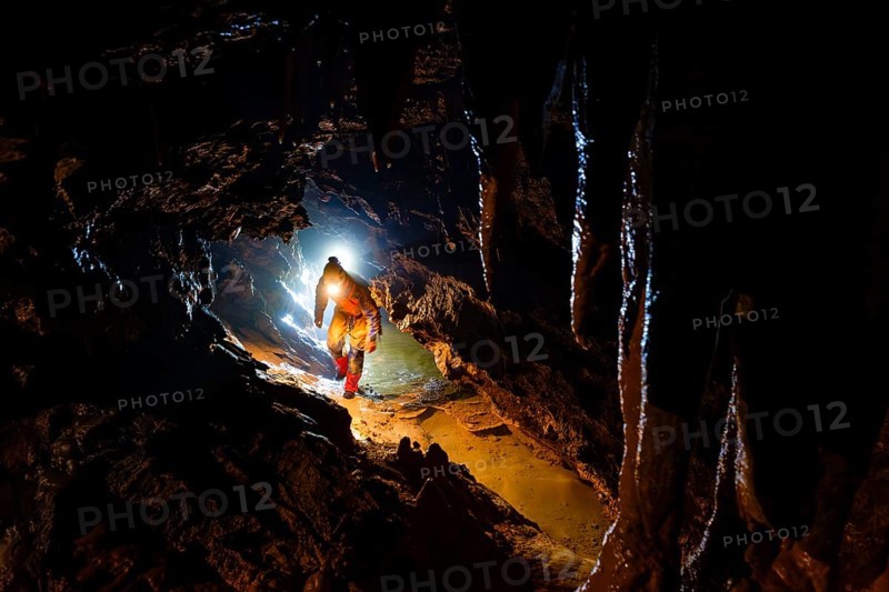 Speleologists climbing through a passage, Advent Cave, Schneizlreuth, Berchtesgadener Land, Upper Bavaria, Bavaria, Germany
