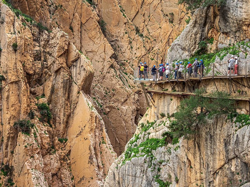 Tourists on the elevated path of the caminito del rey, along a deep gorge, Andalusia, Spain