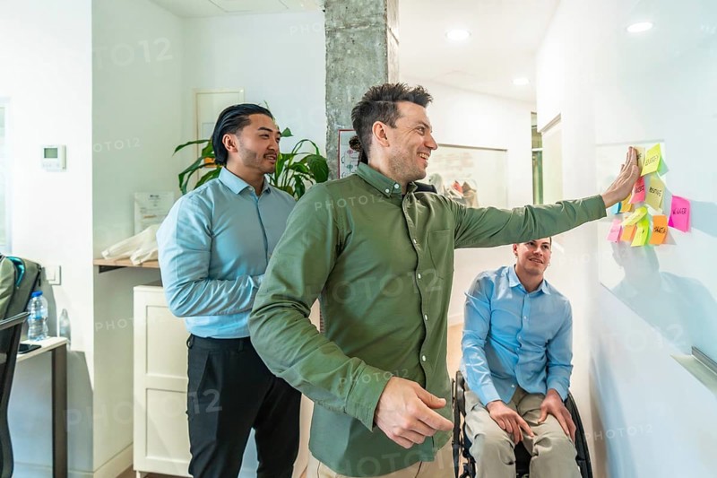 Business colleagues discussing ideas written on sticky notes during a productive meeting in a modern office