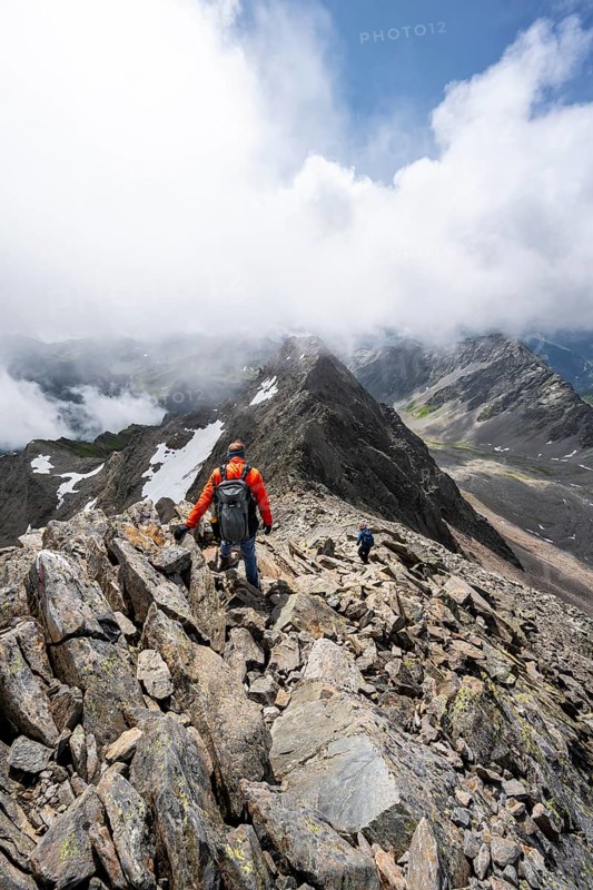 Mountaineer on the summit of Lasörling, cloudy mountain landscape, Lasörling Group, Hohe Tauern National Park, East Tyrol, Tyrol, Austria
