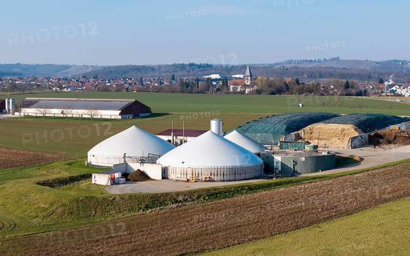 Modern biogas plant in a rural setting with a view of a village and wide fields, near Backnang, Rems-Murr district, Baden-Württemberg, Germany