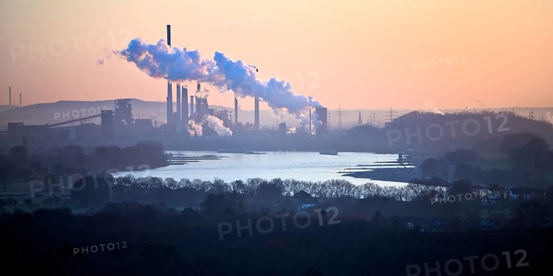 View in front of sunrise from the Rheinpreussen spoil tip onto the Rhine in Duisburg with the Thyssen Krupp plant in Bruckhausen, Germany