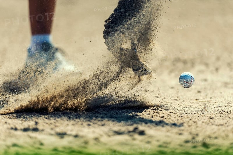 A golf ball is hit out of the bunker
