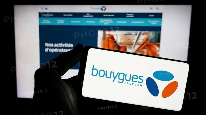 Stuttgart, Germany, 11-22-2023: Person holding smartphone with logo of French telecommunications company Bouygues Telecom S.A. in front of website. Focus on phone display