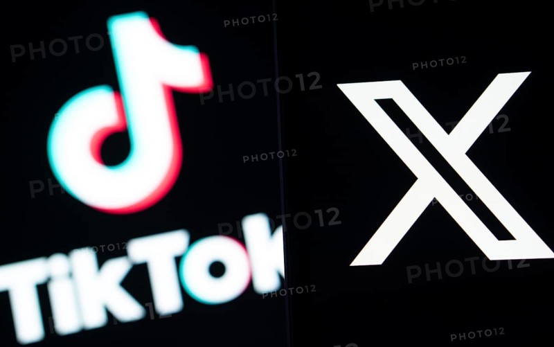 Twitter (X) logo is seen on a smartphone and Tiktok logo in the background