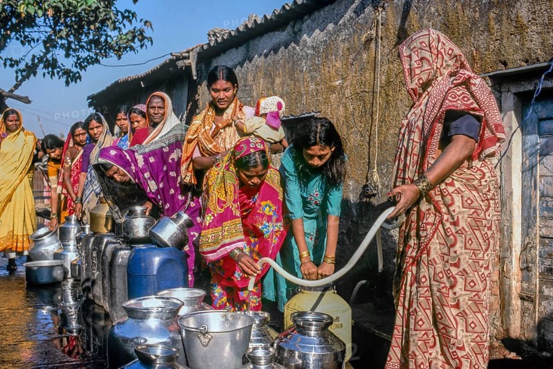 Women standing in queue to collect water in slum, Mumbai, Maharashtra, India, Asia