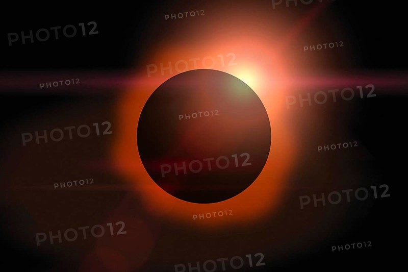 Solar eclipse with orange halo on black sky background