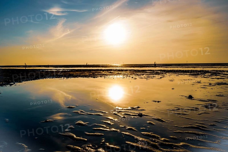 Sunset with clear reflection in the calm water on a sandy beach, North Sea beach 27476 Cuxhaven/Sahlenburg-Germany