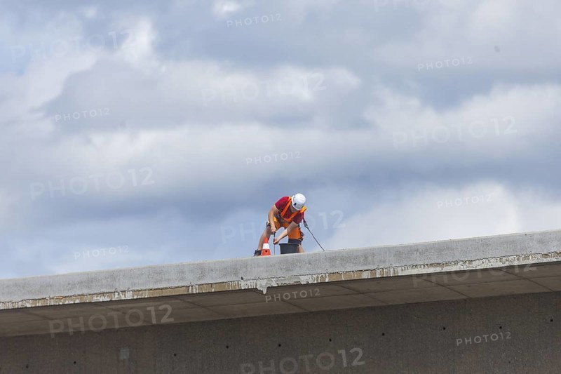 Following the partial collapse of the Carola Bridge, demolition work is continuing. A new change of technology, in which the bridge sections are to be channelled into folded beds, is currently being prepared by backfilling work. A worker secured with a rope is working on the markings on the bridge remains, Dresden, Saxony, Germany