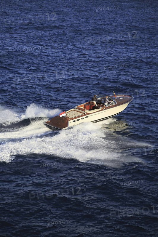 Aerial view sports boat J Craft 42 Torpedo R at full speed on the Cote d'Azur, luxurious motorboat from the Swedish shipyard J Craft Boats with Volvo Penta engine in vintage style of the 50s and 60s in the style of the Riva boats, Mediterranean Sea