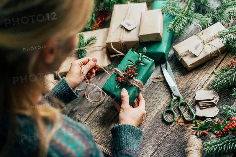 Unrecognizable woman decorating Christmas gifts