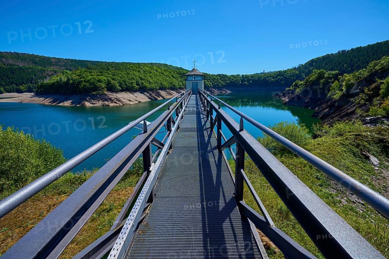 Metal footbridge over a large water reservoir, surrounded by green landscape, summer, Urft dam wall, Obersee, Urftsee, Schleiden, Eifel National Park, Eifel, North Rhine-Westphalia, Germany