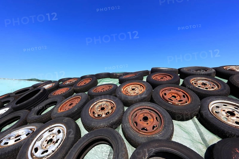 Old wheels, rims and tyres, used here to weigh down the cover of an agricultural silo