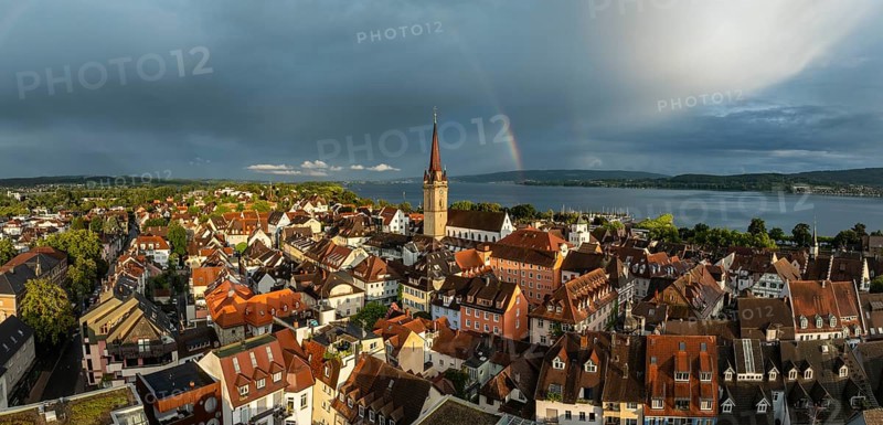 Luftbild, Panorama von der Stadt Radolfzell am Bodensee mit der historischen Altstadt und dem Radolfzeller Münster nach einem Gewitterschauer von der Abendsonne angestrahlt, am Horizont ein Regenbogen, Landkreis Konstanz, Baden-Württemberg, Deutschland