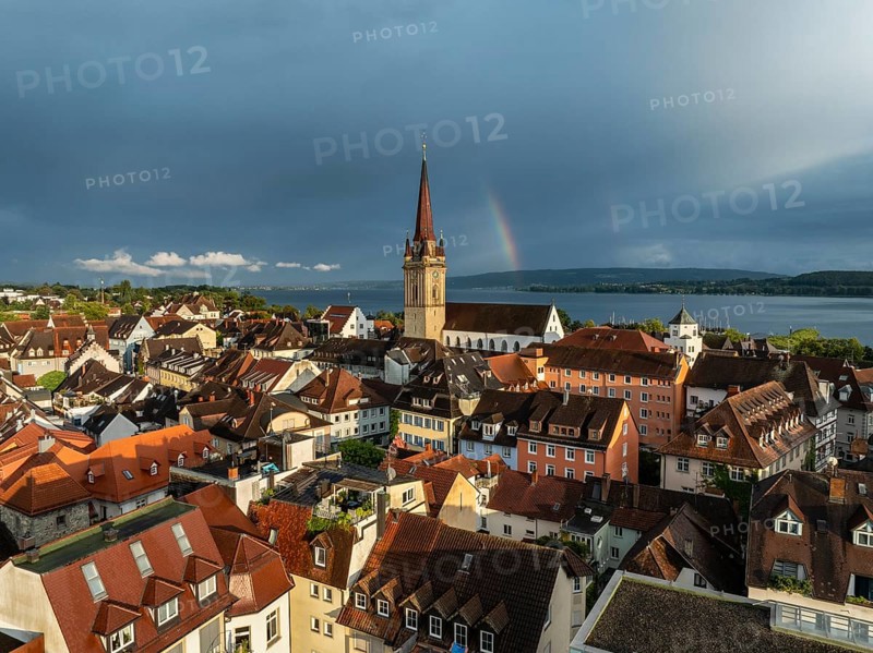 Luftbild von der Stadt Radolfzell am Bodensee mit der historischen Altstadt und dem Radolfzeller Münster nach einem Gewitterschauer von der Abendsonne angestrahlt, am Horizont ein Regenbogen, Landkreis Konstanz, Baden-Württemberg, Deutschland
