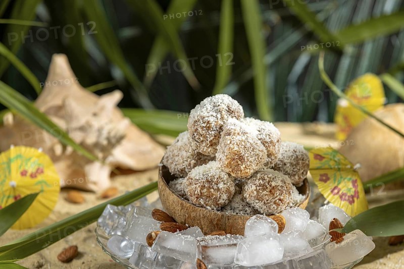 Almond and chocolate confectionery in a coconut on ice cream with umbrellas on sand