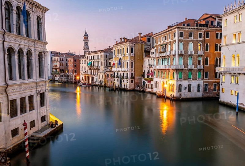 View of the Grand Canal at sunset, picturesque evening mood with illuminated palazzos on the canal and the church tower of the Chiesa Parrocchiale dei Santi Apostoli, long exposure, view from the Rialto Bridge, Venice, Veneto, Italy