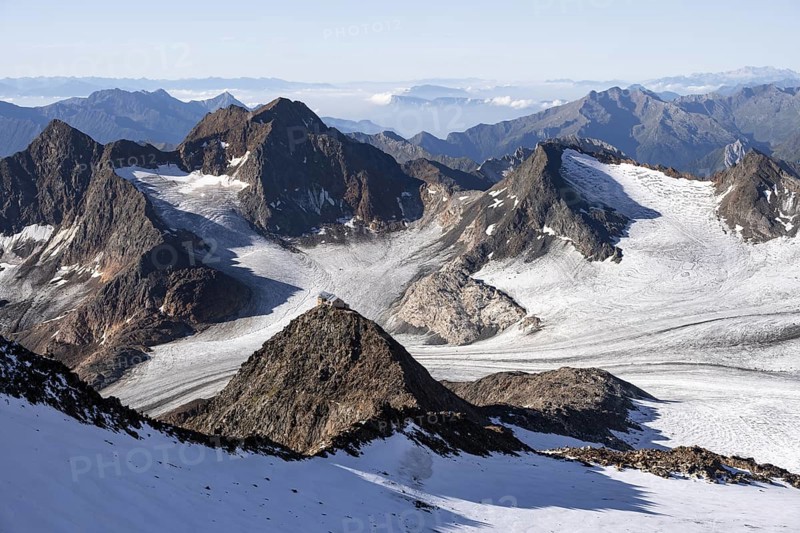 At the summit of Wilder Freiger, picturesque high mountain landscape with snow, view of Übeltalferner glacier and rocky mountain peaks Königshofspitz and Sonklarspitze, Stubai Alps, South Tyrol, Italy