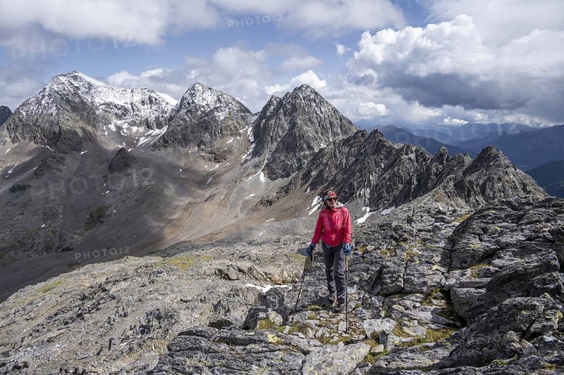 Female mountaineer on the summit of Keeskopf, behind summit of Petzeck, Hoher Perschitzkopf and Kruckelkopf, Schober Group, Hohe Tauern National Park, Carinthia, Austria