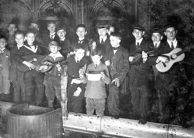 Boys in school uniform giving a performance, 1930s, Young men with guitars and mandolins, one drinking from a bowl, historical photo