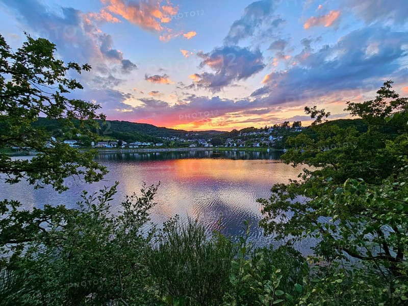 Colourful sunset over a calm lake, surrounded by trees and reflecting clouds in the sky, summer, Rursee, Rurtalsperre, Rurberg, Simmerath, Eifel National Park, North Rhine-Westphalia, Germany