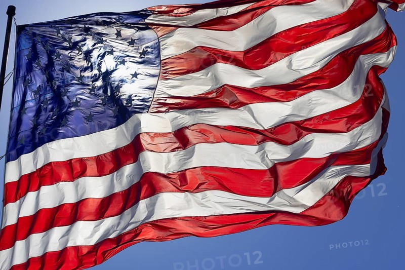 Dramatic backlit american flag waving in the wind