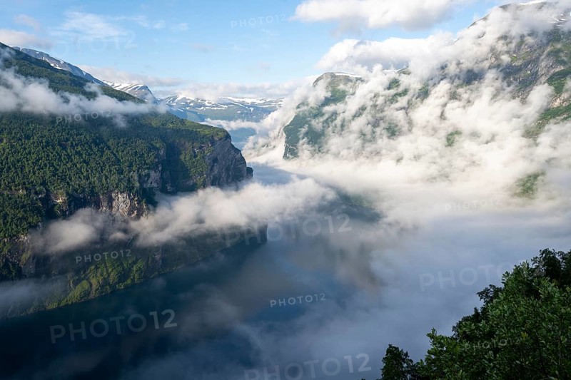 View over the Geirangerfjord, atmospheric clouds over the fjord in the morning light, Ørnesvingen viewpoint, near Geiranger, Møre og Romsdal, Norway