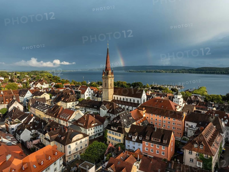 Luftbild von der Stadt Radolfzell am Bodensee mit der historischen Altstadt und dem Radolfzeller Münster nach einem Gewitterschauer von der Abendsonne angestrahlt, am Horizont ein Regenbogen, Landkreis Konstanz, Baden-Württemberg, Deutschland