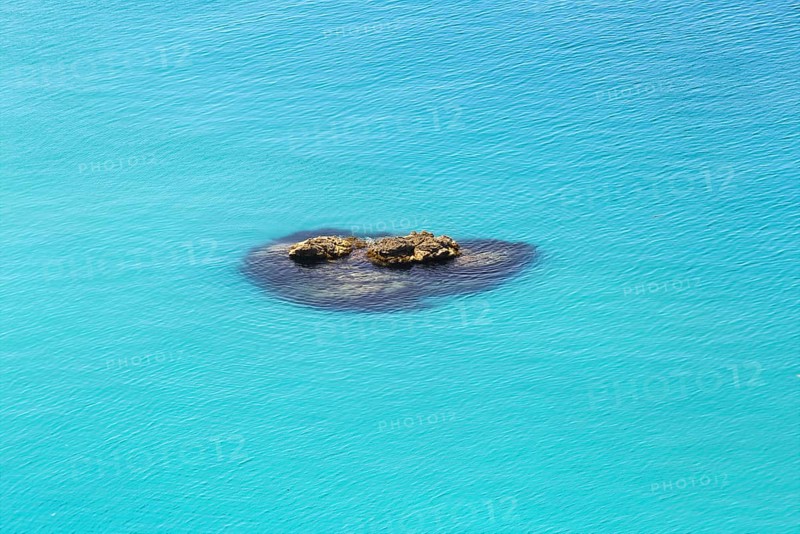 Small group of rocks in the turquoise-coloured sea with calm water, Ricadi, Capo Vaticano
